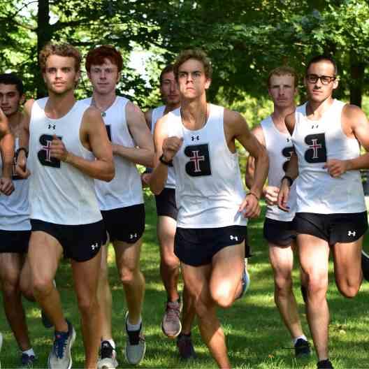 Men cross country team running in a pack